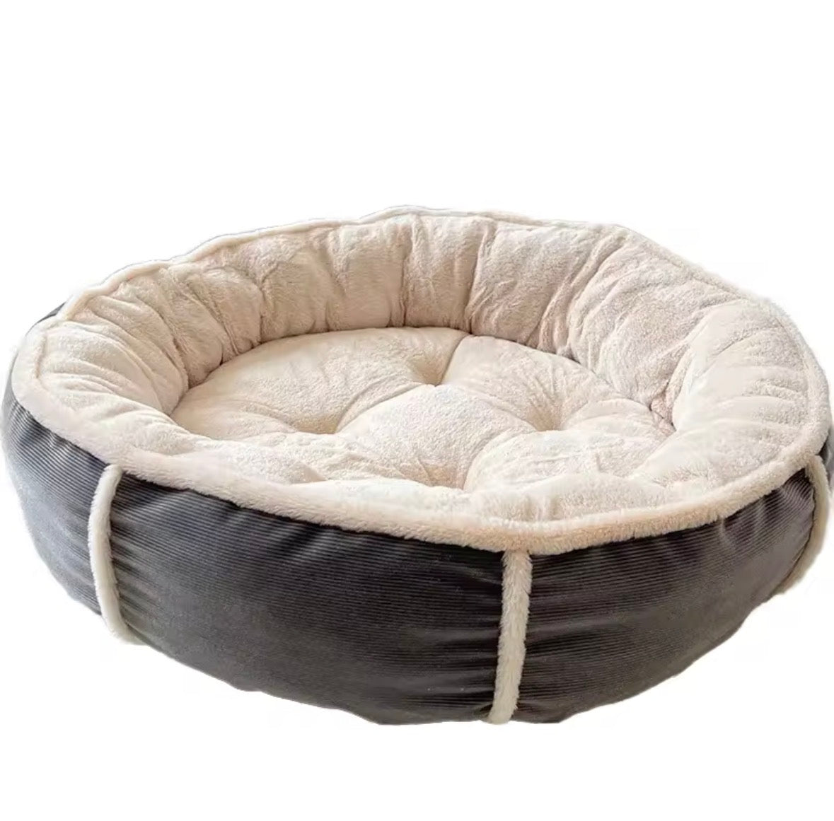 round, bolstered pet bed featuring a dark grey corduroy exterior and a soft, cream-colored plush interior.